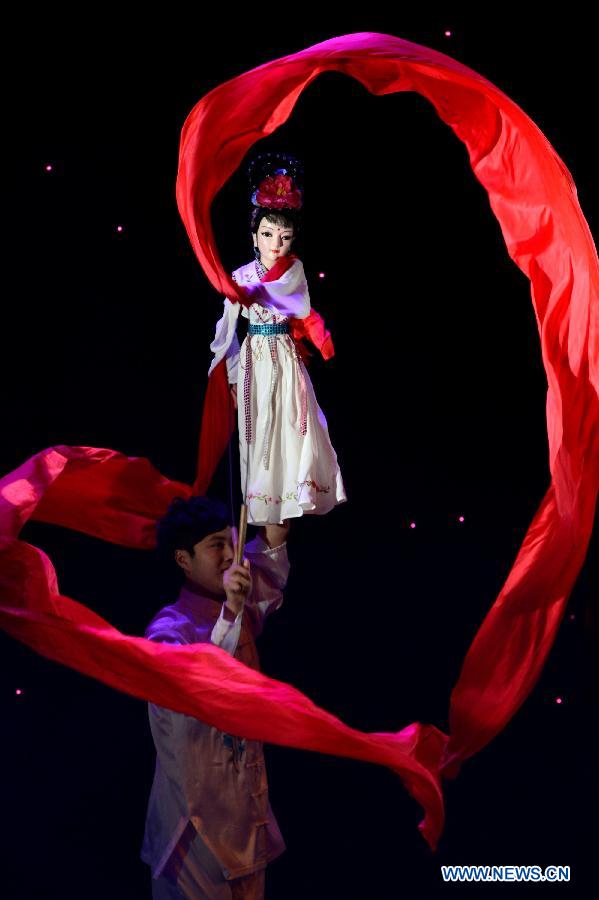 An artist controls a puppet during the 4th national puppet show and shadow play competition in Xi'an, capital of northwest China's Shaanxi Province, Dec. 13, 2012. Sixteen team from the nation would perform 51 shows during the competition.(Xinhua/Li Yibo) 
