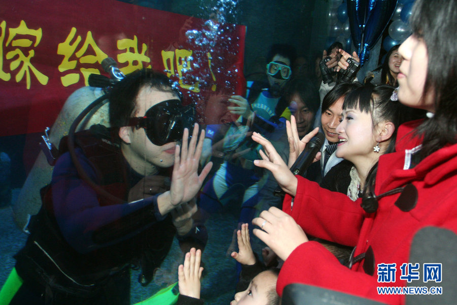 A man in southeastern Chinese city of Fuzhou proposes by diving in an aquarium, Mar. 7, 2010. (Photo/Xinhua)