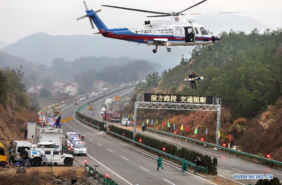 An "injured" person is rescued by a helicopter during the 2012 highway traffic emergency drill in Yingshan County, central China's Hubei Province, Dec. 13, 2012. The drill held on Thursday involved over 800 personnel from armed police, fire control, medical rescue and other departments. (Xinhua/Wan Xiang) 