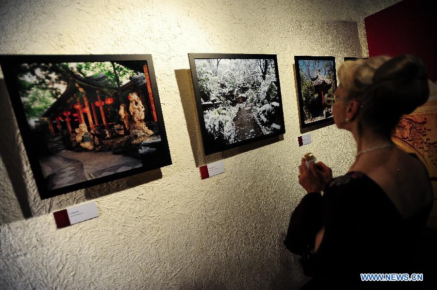 A visitor looks at photos during the "Elegance of Imperial Family, Gongwang Mansion" exhibition in Santiago, capital of Chile, on Dec. 12, 2012. The exhibition presented an opportunity to show the brilliance of Chinese culture through beauty of Chinese architectures and life styles. (Xinhua/Jorge Villegas) 