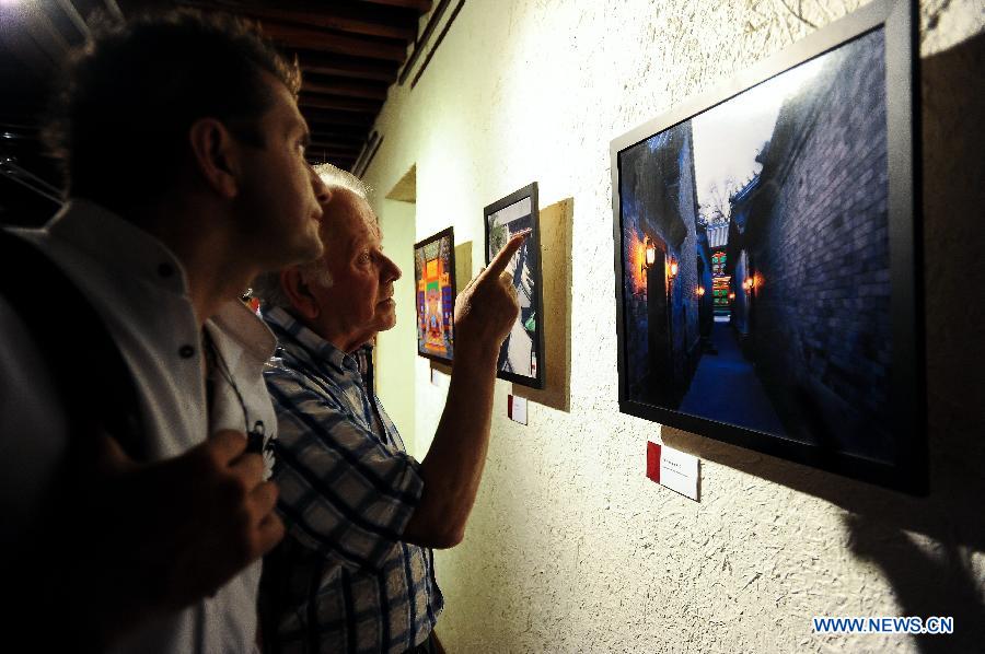 Visitors look at photos during the "Elegance of Imperial Family, Gongwang Mansion" exhibition in Santiago, capital of Chile, on Dec. 12, 2012. The exhibition presented an opportunity to show the brilliance of Chinese culture through beauty of Chinese architectures and life styles. (Xinhua/Jorge Villegas) 