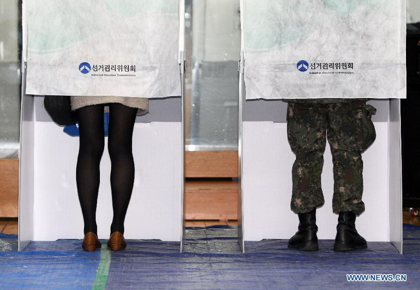 A South Korean soldier and a woman cast absentee ballots for the upcoming presidential election at a polling station in Seoul, South Korea, Dec. 13, 2012. The election will take place on Dec. 19. (Xinhua/Park Jin-hee) 