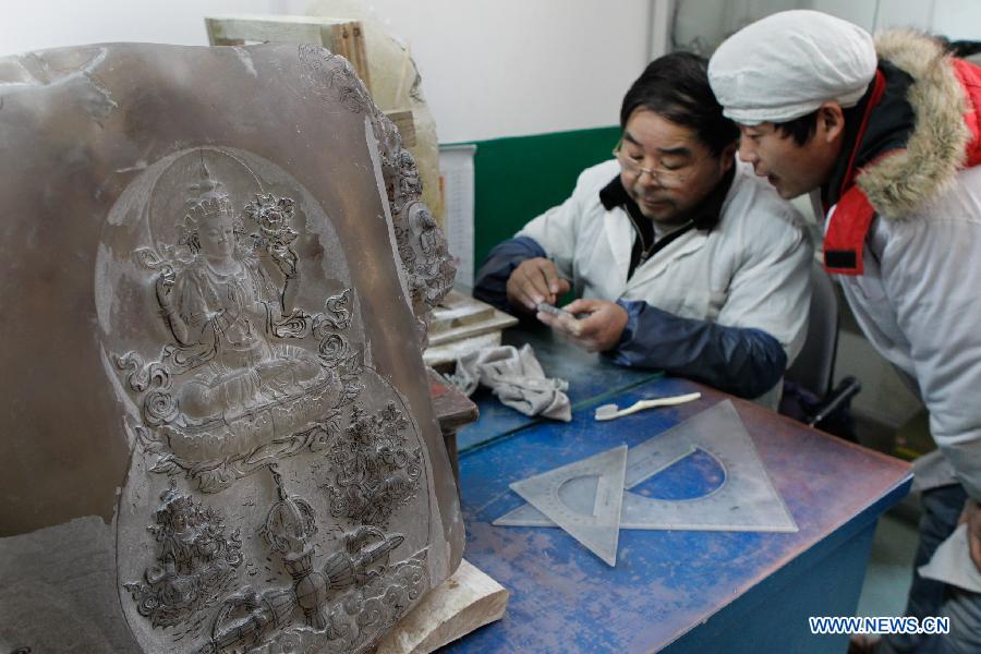 Two apprentices of Taiwanese sculptor Hung Fu-shou work in Hung's company in Taizhou, east China's Jiangsu Province, Dec. 8, 2012. (Xinhua/Xue Dongmei)