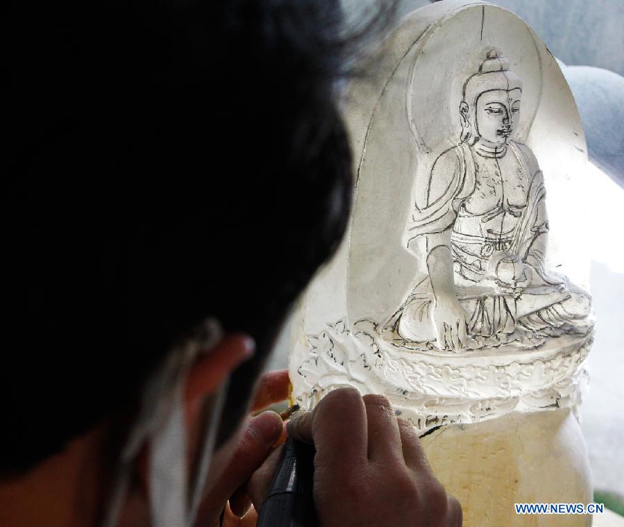 An apprentice of Taiwanese sculptor Hung Fu-shou works on a crystal material in Taizhou, east China's Jiangsu Province, Dec. 8, 2012. (Xinhua/Xue Dongmei)