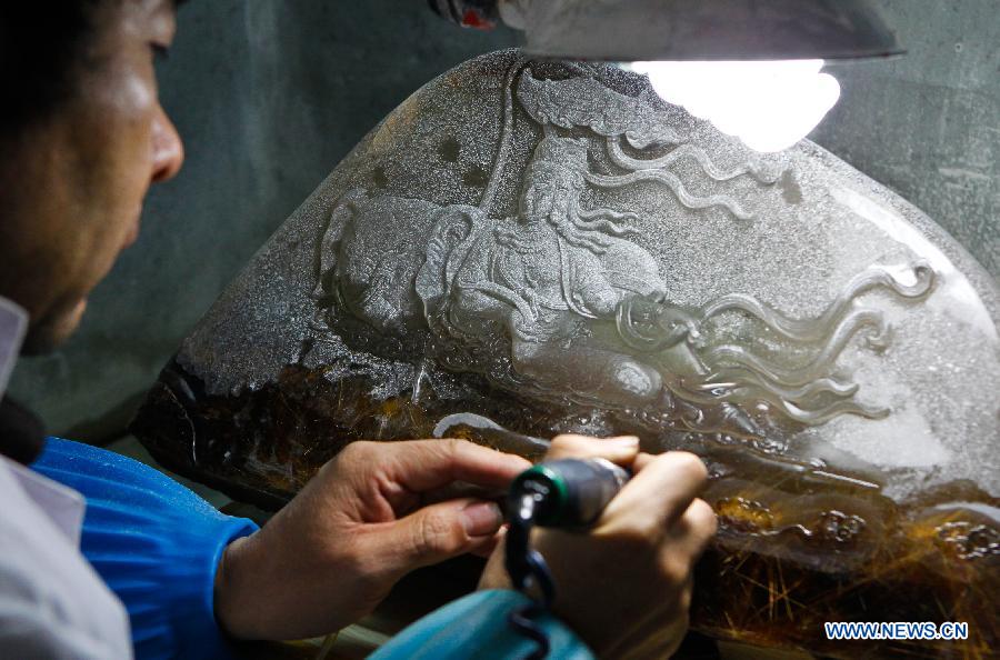 An apprentice of Taiwanese sculptor Hung Fu-shou works on a crystal material in Taizhou, east China's Jiangsu Province, Dec. 8, 2012. (Xinhua/Chen Lin)