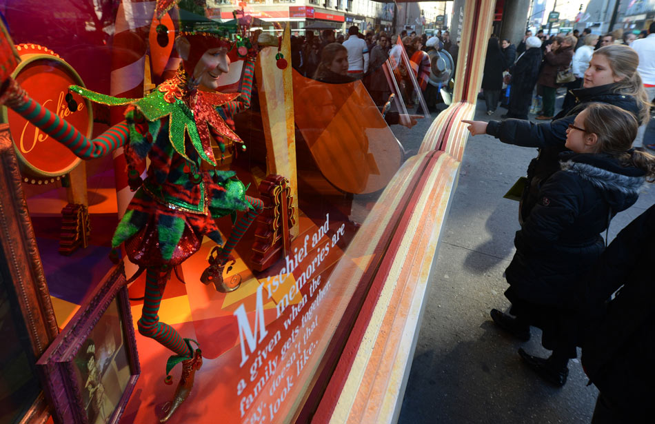 Tourists look at the dolls in the Christmas window of Macy's in Manhattan, New York, U.S. Dec. 13, 2012.(Xinhua/Wang Lei)