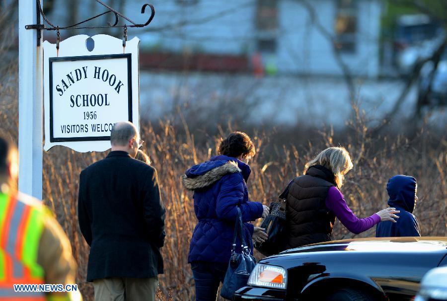 Escorted by his family members, a child (R) leaves the Sandy Hook Elementary School after the fatal school shooting in Newtown, Connecticut, the United States, Dec. 14, 2012. Police in U.S. state Connecticut said Friday that 18 children died on the scene at the school shooting here in Sandy Hook Elementary School, two more died later in the hospital. All together 8 adults were also dead. (Xinhua/Wang Lei) 