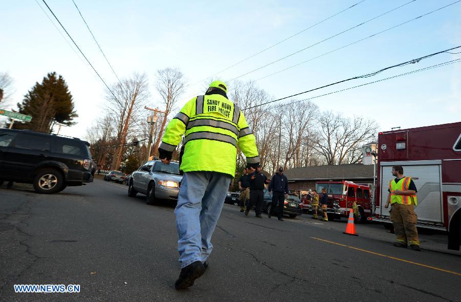 A rescuer stands guard near the Sandy Hook Elementary School after the fatal school shooting in Newtown, Connecticut, the United States, Dec. 14, 2012. Police in U.S. state Connecticut said Friday that 18 children died on the scene at the school shooting here in Sandy Hook Elementary School, two more died later in the hospital. All together 8 adults were also dead. (Xinhua/Wang Lei) 