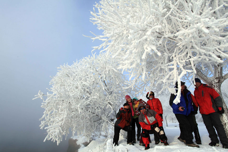 Tourists pose for photos on Rime Island in Jilin city, Northeast China's Jilin province, on Dec 9, 2012. The rime in the city arrived earlier and thicker this year, creating a beautiful view which attracted many visitors. (Photo/Xinhua) 