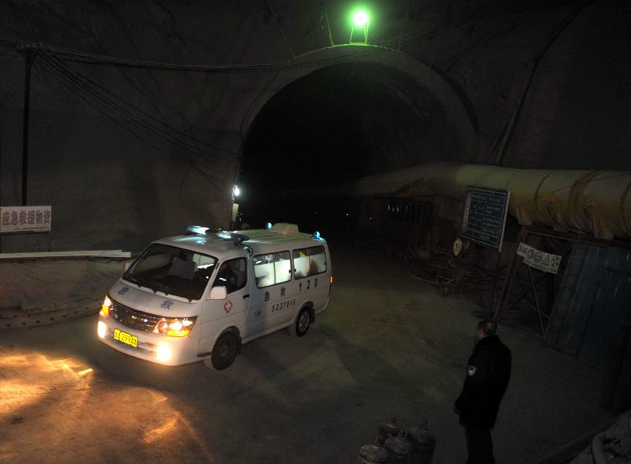 An ambulance with survived workers leaves a railway tunnel in Lanzhou, capital of northwest China's Gansu Province, Dec. 14, 2012. Five construction workers who were buried in a tunnel that was under construction around 2:50 p.m. on Wednesday were rescued at 10:07 p.m. Friday. (Xinhua/Nie Jianjiang)