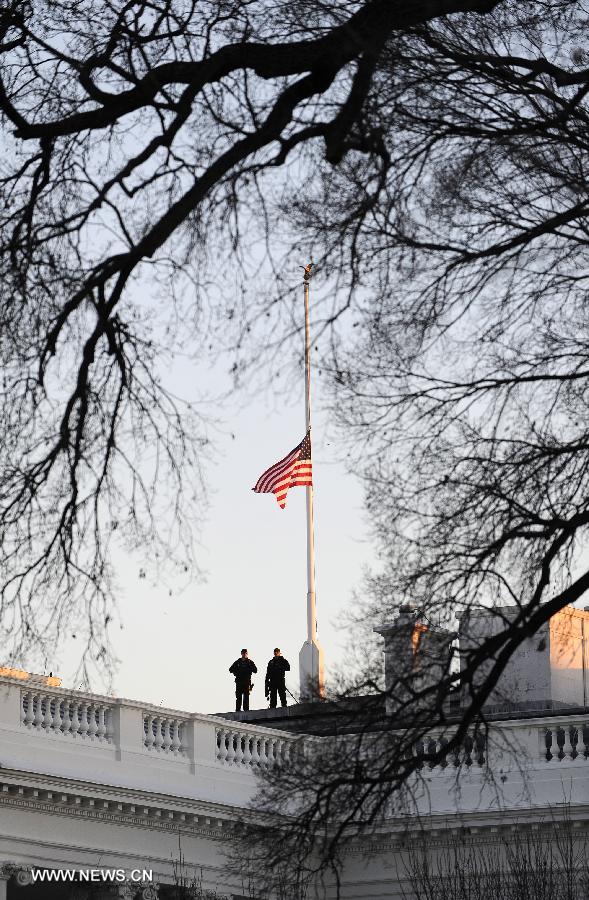 Security personnel are seen beside a U.S. flag flying at half staff to honor the victims of the Connecticut shooting incident at the White House in Washington D.C., capital of the United States, Dec. 14, 2012. U.S. President Barack Obama on Friday ordered U.S. flags to be flown at half-staff at the White House and all public buildings and grounds, as a mark of respect for the victims of a deadly shooting spree at Sandy Hook Elementary School in Newtown, Connecticut, which took place earlier in the day. (Xinhua/Wang Yiou) 