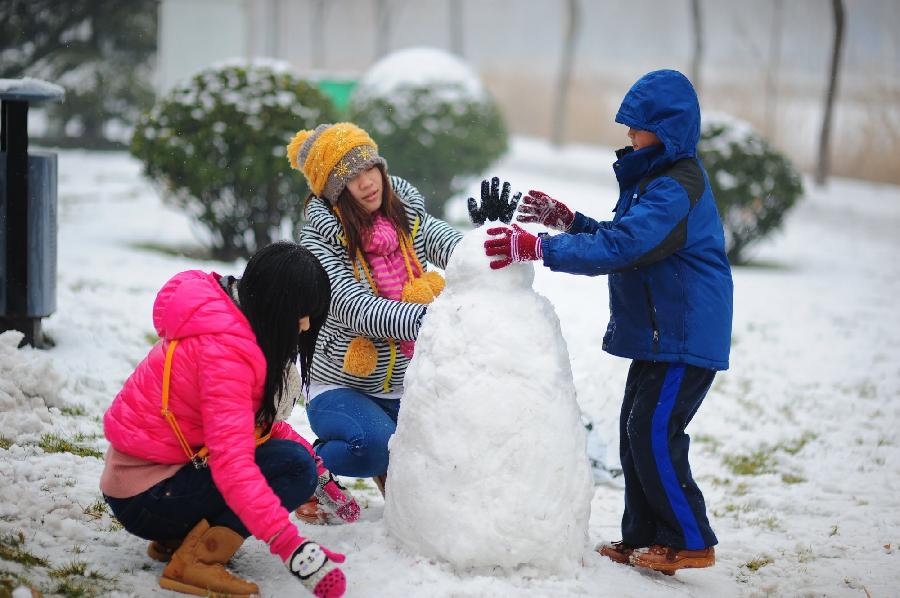 People play snow at a park in Tianjin, north China, Dec. 14, 2012. Citizens went outdoors to enjoy themselves after heavy snow swept Tianjin on Friday. (Xinhua)