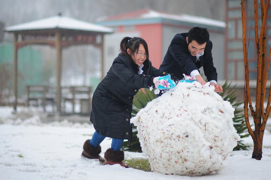People play snow at a park in Tianjin, north China, Dec. 14, 2012. Citizens went outdoors to enjoy themselves after heavy snow swept Tianjin on Friday. (Xinhua)