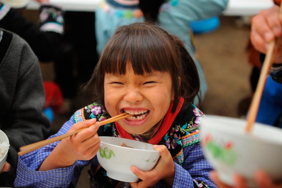 A Bouyei girl enjoys her lunch in an elementary school, Guizhou Province, on Dec. 12, 2012. Up to now, the program “nutritious lunch“ has covered 65 counties and benefited 4 millions students in Guizhou Province. (Xinhua/Liu Xu)
