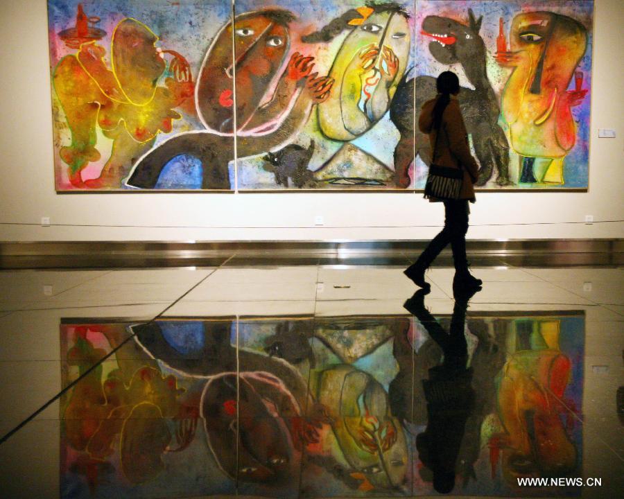 A citizen views a painting of Juan Ripolles, a well-known Spanish painter and sculptor, at his exhibition "Universe Ripolles" in the Jiangsu Provincial Art Museum in Nanjing, capital of east China's Jiangsu Province, Dec. 16, 2012. A total of 86 artworks of Juan Ripolles were displayed at the exhibition, which kicked off on Tuesday. (Xinhua) 