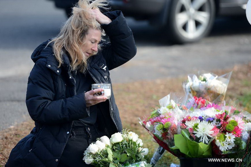 Local resident Jaeger Andrea holds a candle cup near Sandy Hook Elementary School, where a gunman opened fire on school children and staff in Newtown, Connecticut, Dec. 15, 2012. A shooting incident on Friday morning in the elementary school in Newtown of the Connecticut State of the United States killed at least 28 people, including 20 children. (Xinhua/Wang Lei) 