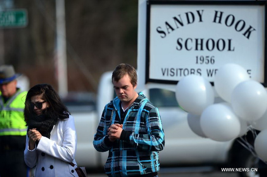 Local residents pray for victims near Sandy Hook Elementary School, where a gunman opened fire on school children and staff in Newtown, Connecticut, Dec. 15, 2012. A shooting incident on Friday morning in the elementary school in Newtown of the Connecticut State of the United States killed at least 28 people, including 20 children. (Xinhua/Wang Lei) 