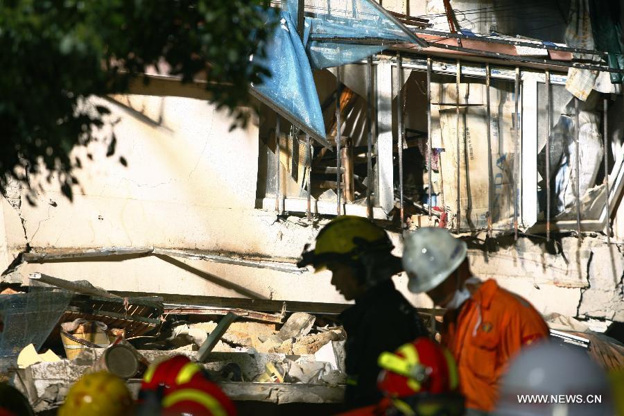 Rescuers search for residents trapped in a collapsed residential building in Ningbo, east China's Zhejiang Province, Dec. 16, 2012. The Five-story residential building collapsed around Sunday noon. The number of casualties is unknown. (Xinhua/Cui Xinyu)