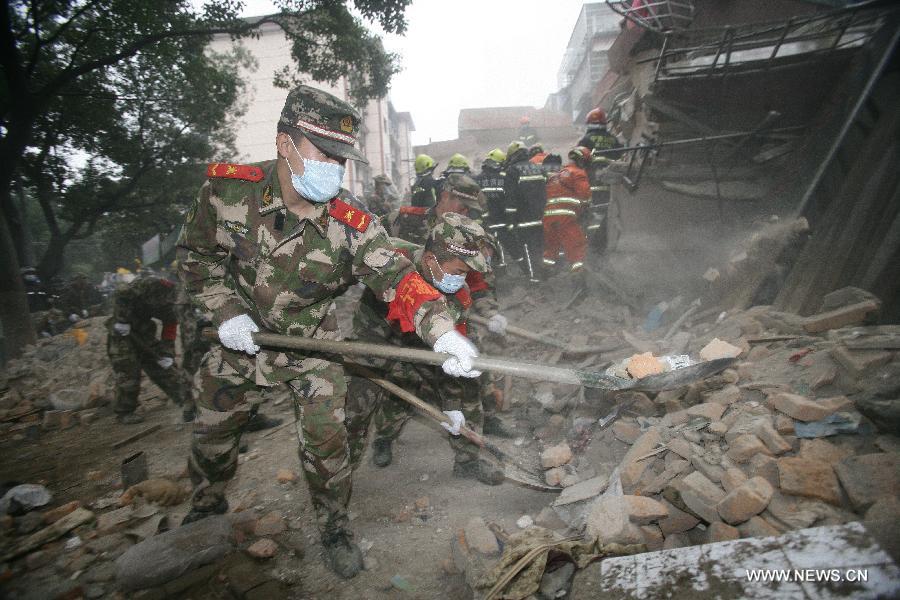 Rescuers clear up debris at a collapsed residential building in Ningbo, east China's Zhejiang Province, Dec. 16, 2012. The Five-story residential building collapsed around Sunday noon. The number of casualties is unknown. (Xinhua/Zhang Peijian)