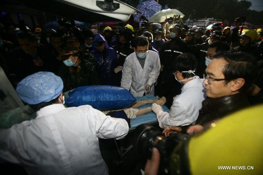 Medical personnel carry a woman rescued out of a collapsed residential building into an ambulance in Ningbo, east China's Zhejiang Province, Dec. 16, 2012. The Five-story residential building collapsed around Sunday noon. The number of casualties is unknown. (Xinhua/Zhang Peijian)