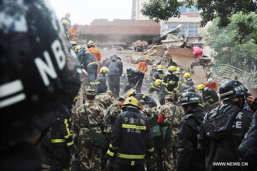 Rescuers clear up debris at a collapsed residential building in Ningbo, east China's Zhejiang Province, Dec. 16, 2012. The Five-story residential building collapsed around Sunday noon. The number of casualties is unknown. (Xinhua)