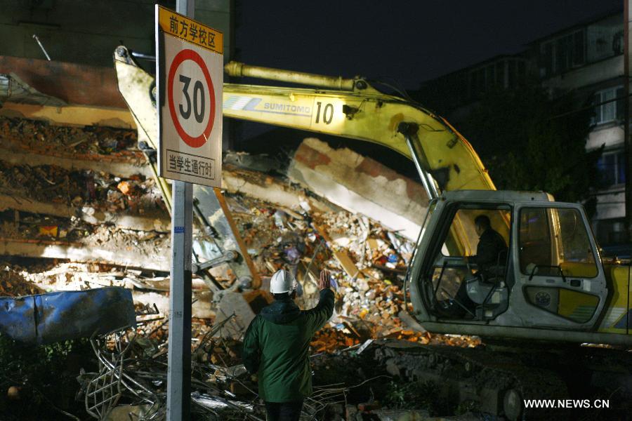 Rescuers clear up debris at a collapsed residential building in Ningbo, east China's Zhejiang Province, Dec. 16, 2012. The Five-story residential building collapsed around Sunday noon. The number of casualties is unknown. (Xinhua/Cui Xinyu)