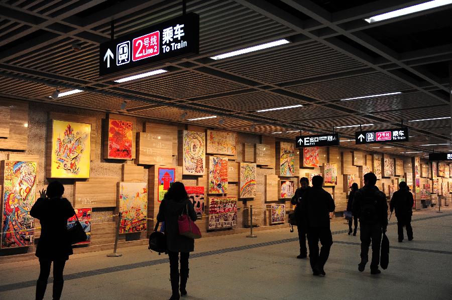 Citizens view pictures created by pupils at the Hongshan Suqare Station of Subway Line No. 2 in Wuhan, capital of central China's Hubei Province, Dec. 14, 2012. Subway Line No.2 is the first subway line of the city, also the first subway line across the Yangtze River. The construction of the project started in 2006. It is expected to be put into operation in the end of 2012. (Xinhua/Hao Tongqian) 