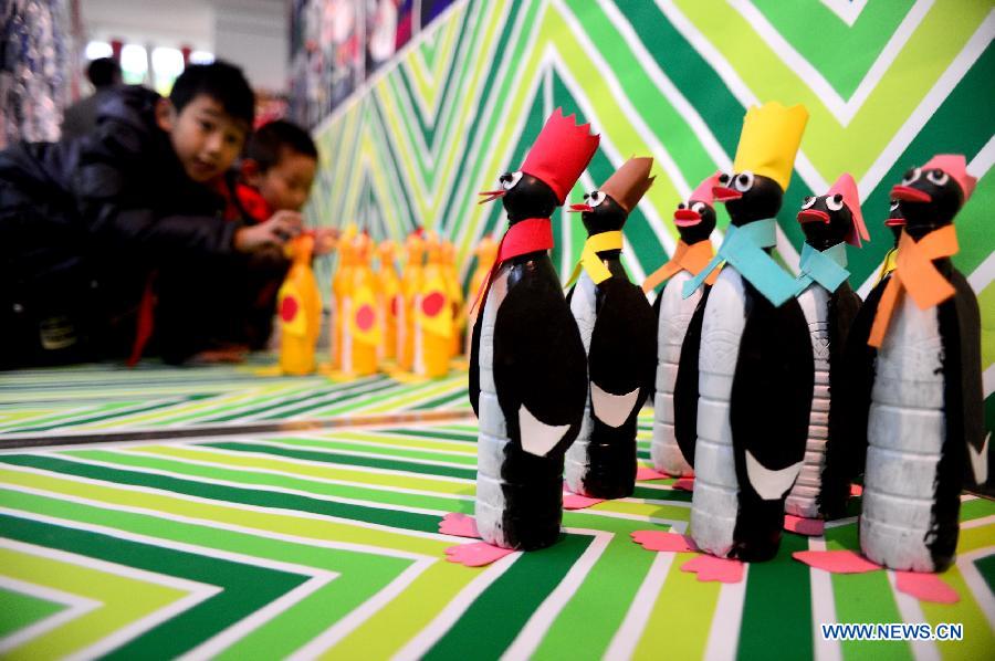Students view handicrafts made of wastes and scraps during an exhibition in Lanzhou, capital of northwest China's Gansu province, Dec. 14, 2012. A ten-day show themed on environmental protection opened here on Friday, during which over 1,800 artworks made by local primary and middle school students are displayed. (Xinhua/Zhang Meng)
