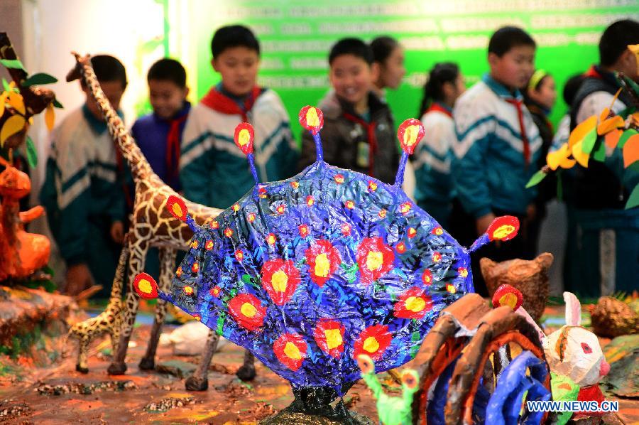 Students view handicrafts made of wastes and scraps during an exhibition in Lanzhou, capital of northwest China's Gansu province, Dec. 14, 2012. A ten-day show themed on environmental protection opened here on Friday, during which over 1,800 artworks made by local primary and middle school students are displayed. (Xinhua/Zhang Meng) 