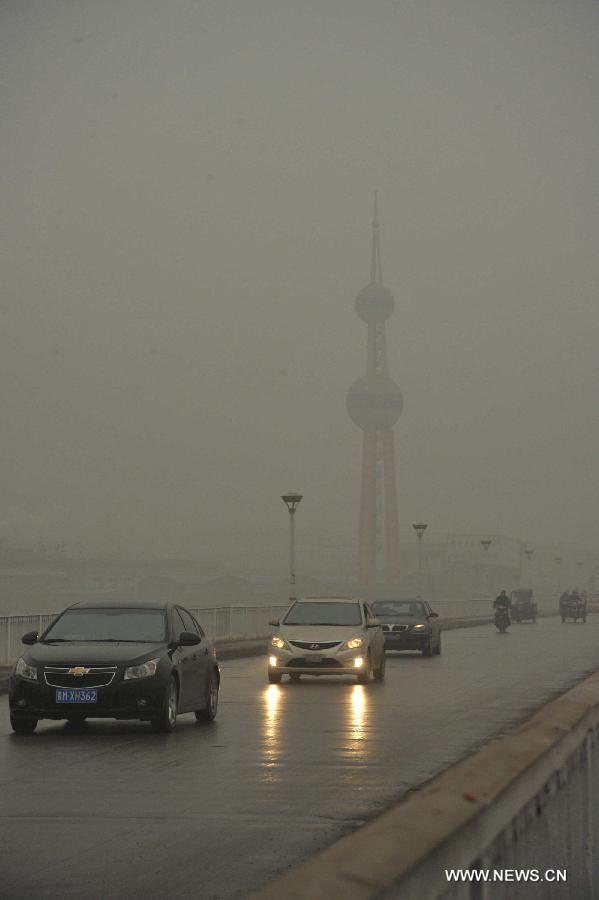 Vehicles move on the fog-enveloped Fenhe River Bridge in Xinjiang County of Yuncheng City, north China's Shanxi Province, Dec. 16, 2012. A heavy fog hit Shanxi on Sunday. (Xinhua/Gao Xinsheng) 