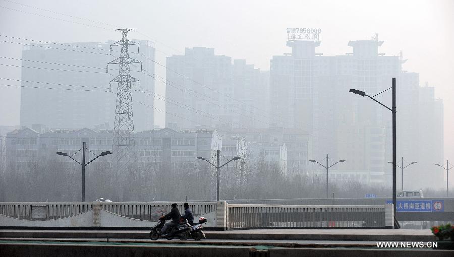 Citizens ride in the fog in Taiyuan, capital of north China's Shanxi Province, Dec. 16, 2012. A heavy fog hit Shanxi on Sunday. (Xinhua/Zhan Yan)