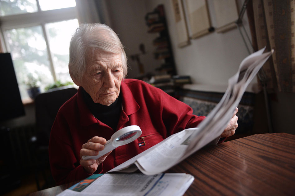 97-year-old Isabel Crook reads newspaper at home on Dec. 14, 2012.(Photo/Xinhua)