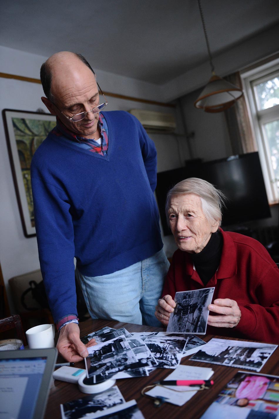 97-year-old Isabel Crook looks at her photos with her son on Dec. 14, 2012.(Photo/Xinhua)
