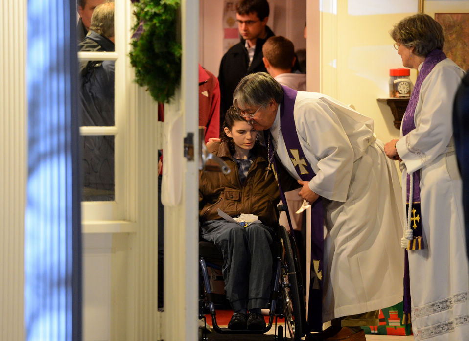 A churchman hugs residents to pray for the victims of the shooting incident at a church. At least 28 people, including 20 children were killed in a shooting incident on Friday morning in the elementary school in Newtown of the Connecticut State of the United States. (Xinhua/Wang Lei)