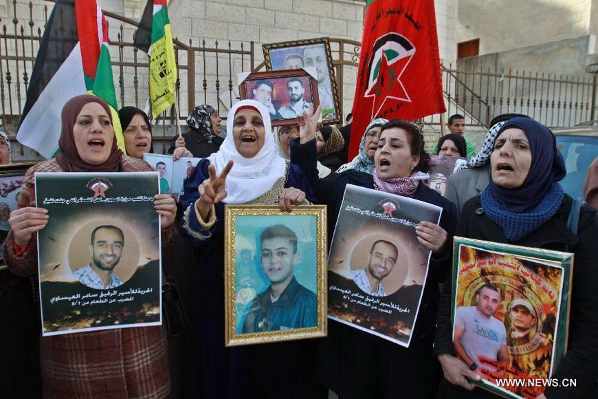 Palestinians attend a rally calling for the release of two Palestinian prisoners in Israeli jails, in the West Bank city of Nablus on Dec. 17, 2012. The two prisoners, Ayman Sharawneh and Samer Isawi, have been going on a hunger strike for over four months in Israeli jails against their administrative detention. (Xinhua/Nidal Eshtayeh)  