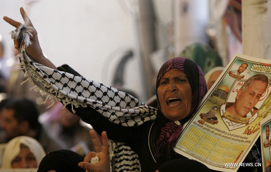 Palestinians attend a rally calling for the release of two Palestinian prisoners in Israeli jails, in the West Bank city of Nablus on Dec. 17, 2012. The two prisoners, Ayman Sharawneh and Samer Isawi, have been going on a hunger strike for over four months in Israeli jails against their administrative detention. (Xinhua/Nidal Eshtayeh)  