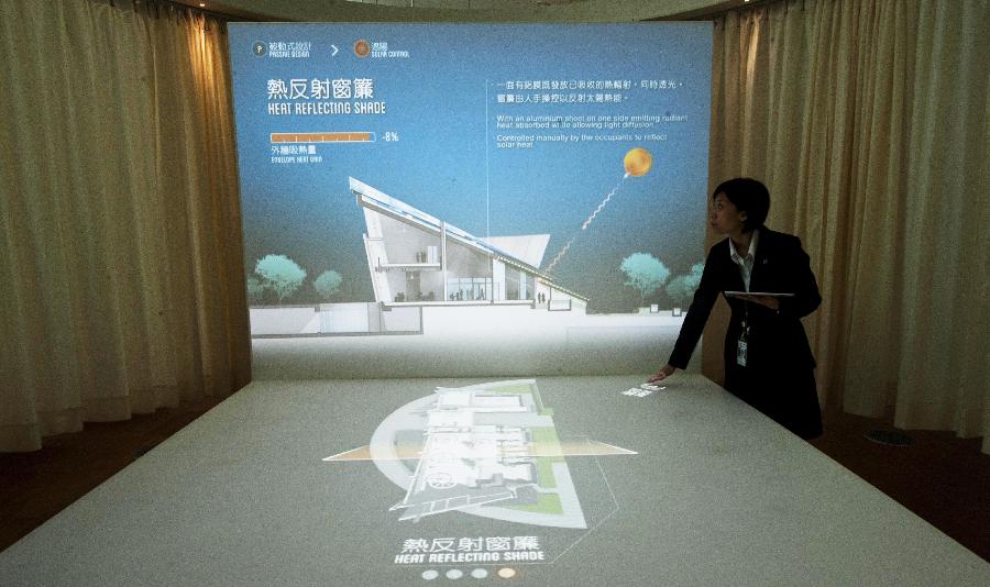 A staff member introduces the design of Hong Kong's first zero-carbon building ZCB in Hong Kong, south China, Dec. 17, 2012. The building, which generates on-site renewable energy more than operation needs from photovoltaic panels and biodiesel tri-generation system and exports surplus energy to offset embodied energy of its construction process and major structural materials, will be opened to the public on Jan. 5, 2013. (Photo/Xinhua) 