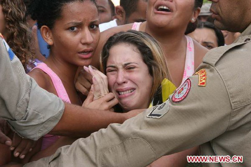 A relative of a victim weeps outside the Tasso da Silveira School in the western region of Rio de Janeiro, Brazil, April 7, 2011. A campus shooting killed 11 people and injured at least 22 others. (Xinhua/Tasso Marcelo/Agencia de Estado)