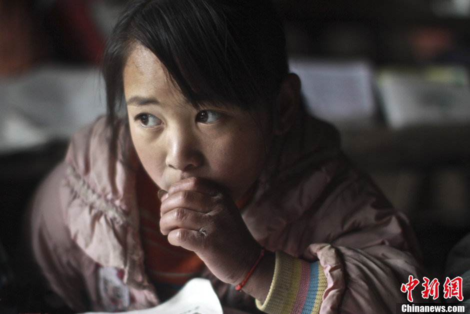 Xiong Shouhui wears a thin jacket, and her hands suffer from frostbite due to the cold weather. Her father has been away for work for eight months. (Chinanews/Feng Zhonghao)