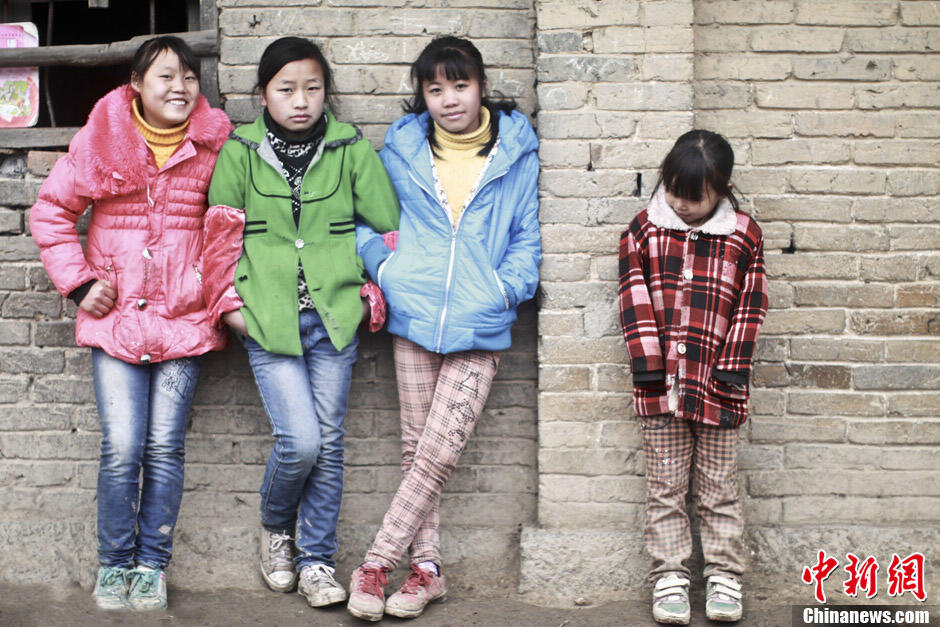 Three 6-grade children and a 3-grade child stand outside the classroom between classes. Tao Jinjun, a high school graduate, is the only teacher in the school, as no teacher is willing to work here. Nishu primary school is in bad needs of educational resources. (Chinanews/Feng Zhonghao)
