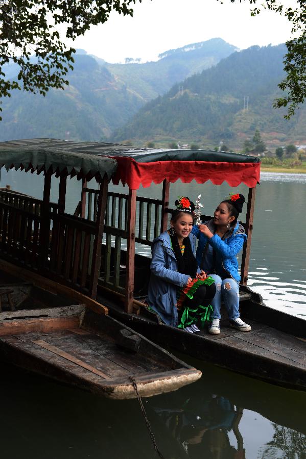 Two girls from Dong ethnic group take a boat for the Sama Festival in Rongjiang County, southwest China's Guizhou Province, Dec. 18, 2012. The Sama Festival, an ancient traditional festival commemorating the woman ancestors of Dong ethnic group, was listed as one of China's state intangible cultural heritages in 2006. The festival of this year will last till Dec. 20. (Xinhua/Peng Nian) 