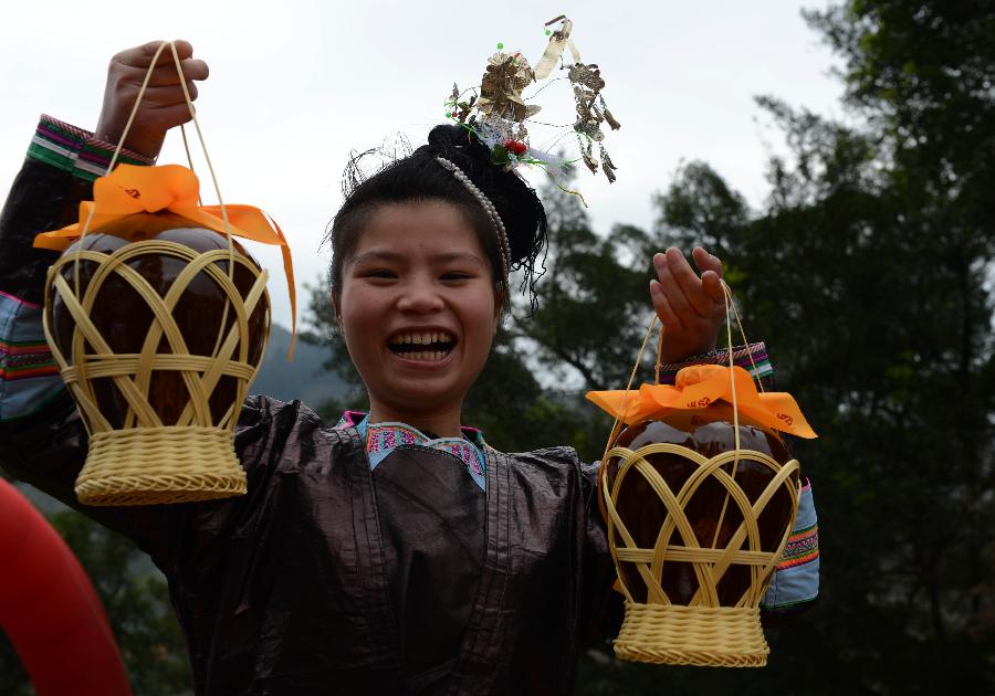A woman from Dong ethnic group takes rice wine to celebrate the Sama Festival in Rongjiang County, southwest China's Guizhou Province, Dec. 18, 2012. The Sama Festival, an ancient traditional festival commemorating the woman ancestors of Dong ethnic group, was listed as one of China's state intangible cultural heritages in 2006. The festival of this year will last till Dec. 20. (Xinhua/Peng Nian) 