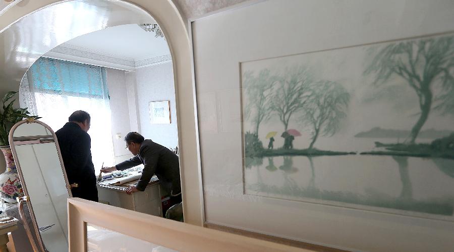 Chinese painter Lu Fang (R) creates a woodblock painting at his studio in Hangzhou City, capital of east China's Zhejiang Province, Dec. 4, 2012. Lu Fang started to create woodblock paintings since 1950s, his works tend to depict the scenery of the West Lake in Hangzhou. The technique of woodblock printing was listed as a state intangbile cultural heritage of China in 2008. (Xinhua/Zhang Chuanqi) 