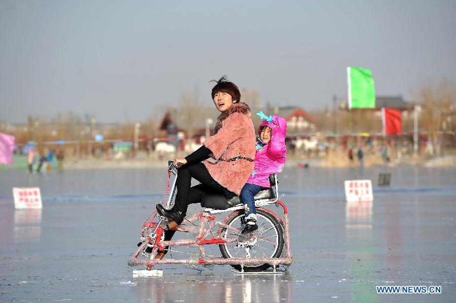 A mother and her daughter ride an ice bike on ice on the Beita Lake in Yinchuan, capital of northwest China's Ningxia Hui Autonomous Region, Dec. 18, 2012. (Xinhua/Peng Zhaozhi)