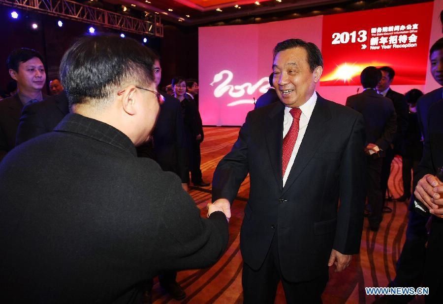 Wang Chen (C), director of China's State Council Information Office, shakes hands with a guest during the New Year reception held by the China's State Council Information Office in Beijing, capital of China, Dec. 18, 2012. (Xinhua/Li Fangyu)