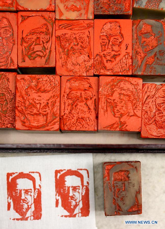Photo taken on Dec. 4, 2012 shows a seal with the portrait of Russian playwright Anton Chekhov (below) and seals with portraits of other famous people, made by Zhang Gengyuan, a portrait seal cutting master in Hangzhou, capital of east China's Zhejiang Province.(Xinhua/Zhang Chuanqi) 
