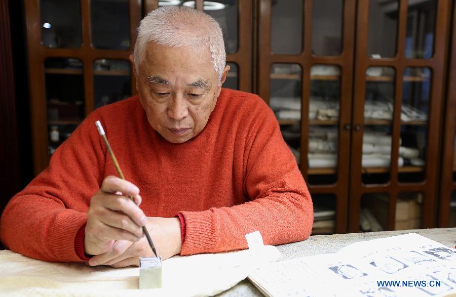 Zhang Gengyuan, a portrait seal cutting master, makes a draft with a brush pen before cutting a portrait seal in his studio in Hangzhou, capital of east China's Zhejiang Province, Dec. 4, 2012. (Xinhua/Zhang Chuanqi) 