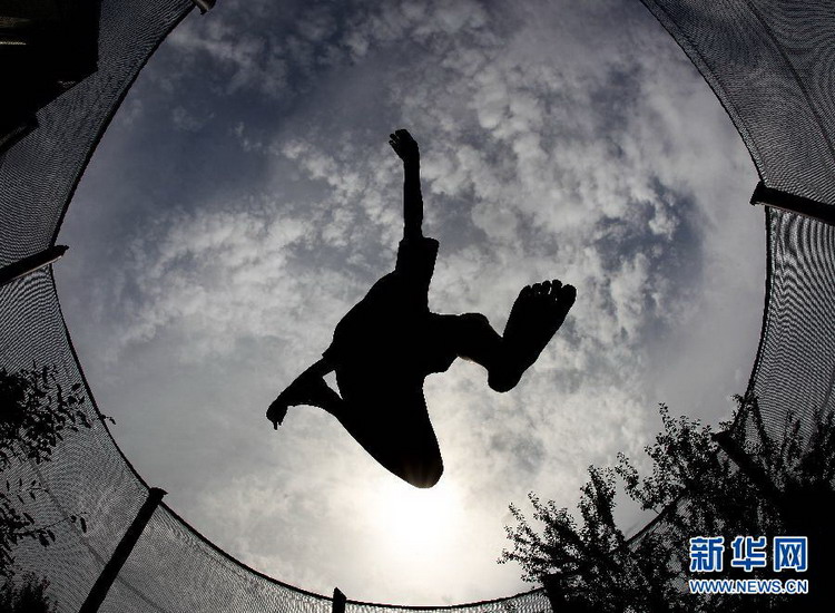 A boy jumps on the trampoline in the garden of Frankfurt, Germany on Aug 21, 2012. (Xinhua/AFP)