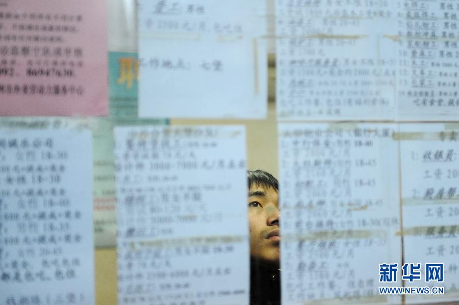 A migrant worker reads the recruitment information on Hangzhou's talent market on Feb. 2, 2012. 