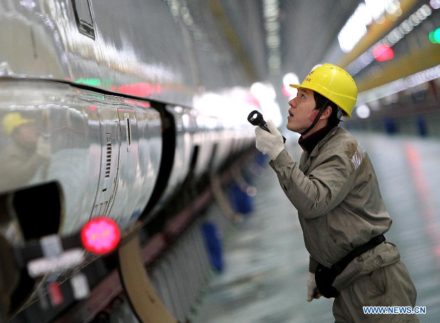 A technician checks the power box of a bullet train in Shanghai Municipality, Dec. 19, 2012. Shanghai Railway Bureau conducted a comprehensive overhaul of all the bullet trains to ensure the demand of vehicles during the coming spring rush on Wednesday. (Xinhua/Chen Fei) 